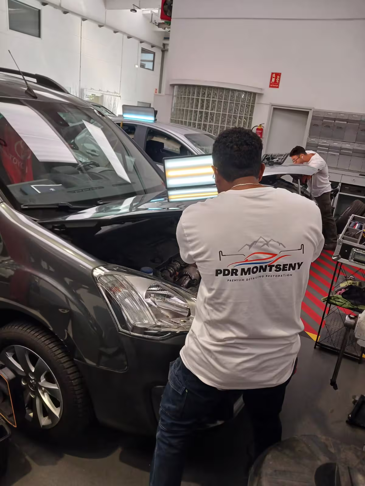 Técnico PDR senior revisando reflejo de carrocería