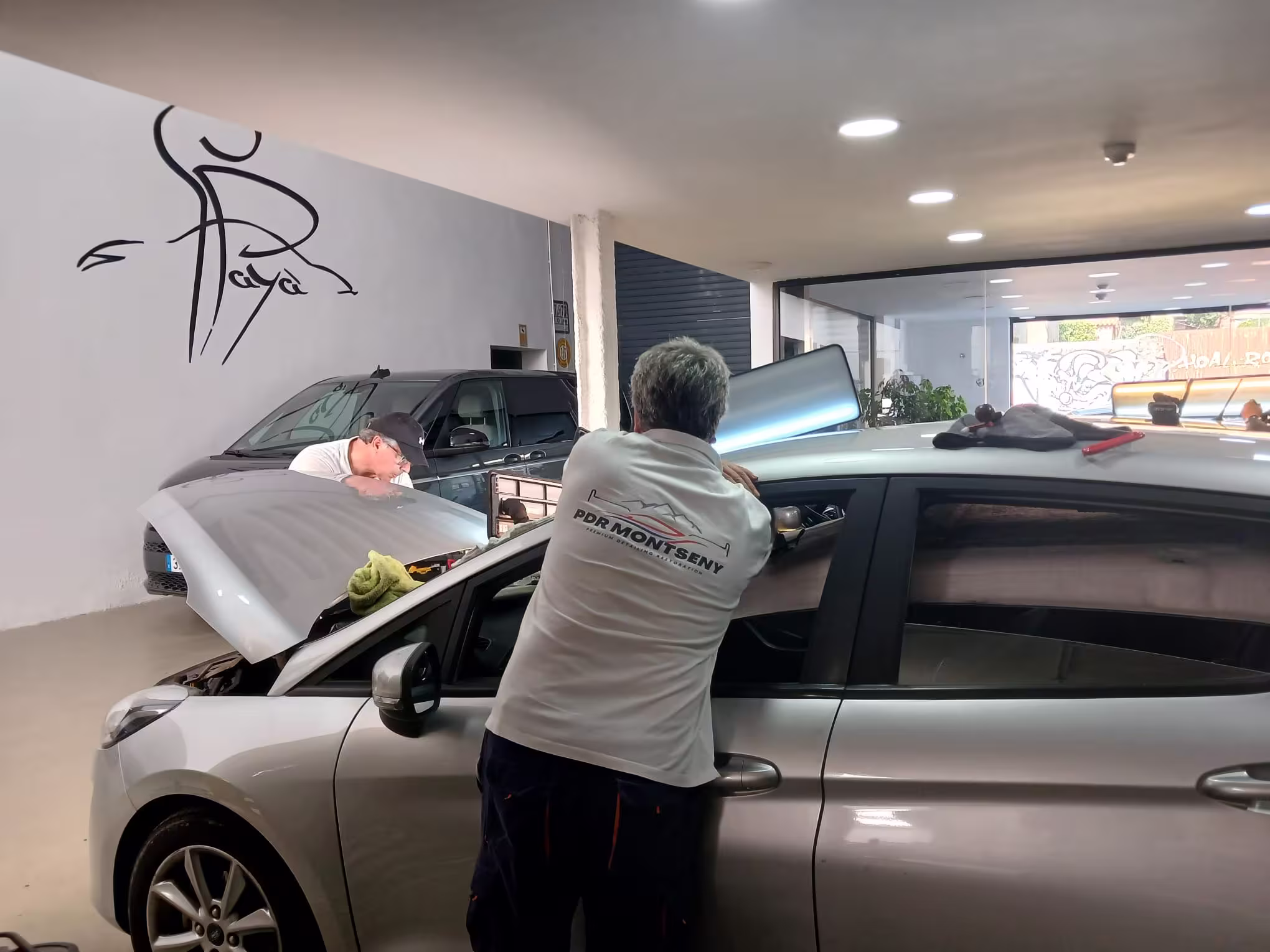 Trabajo PDR sobre lateral de vehículo en taller
